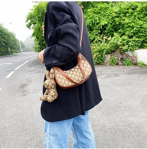 Détail du sac hobo en croissant avec imprimé M et breloque en forme de lapin mignon