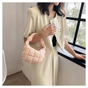 Detailed close-up of a pink quilted cloud bag featuring soft padded square stitching