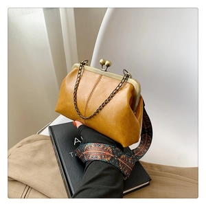 Detail of yellow shell bag with vintage bronze clasp and ethnic patterned strap