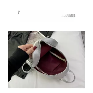 Top view of silver mini backpack showing red fabric interior and storage compartments