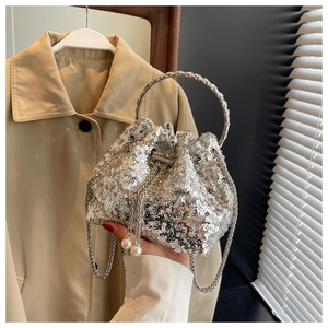 Close-up of silver sequin bucket bag with metal ring handle and elegant pearl charms