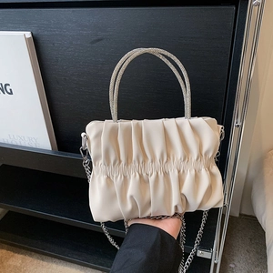 Beige pleated cloud clutch with sparkling rhinestone handles and silver chain strap