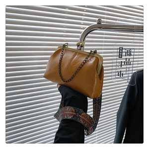 Detail of vintage doctor bag with oil wax leather, metal clasp, and ethnic strap