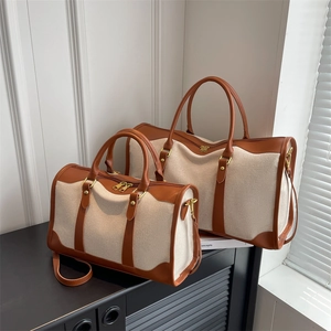 Off-white canvas Boston travel bag set with brown leather trim and dual handles