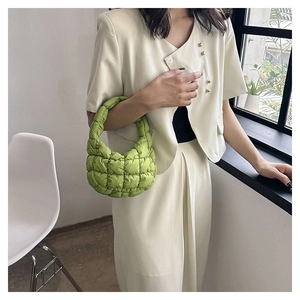 Close-up of bright green quilted puffer handbag with cloud-like pleats and puffy texture