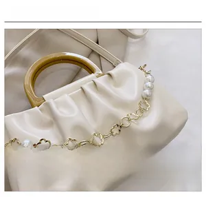 Gros plan du sac nuage blanc avec poignée en résine et chaîne en perles et fleurs