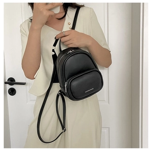 Detail showing the matte black PU leather texture and silver zipper on this mini backpack