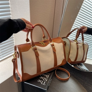 Minimalist canvas and brown leather tote bag with dual handles and long shoulder strap