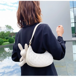 Détail du sac croissant blanc avec imprimé M et charmant pendentif lapin en peluche