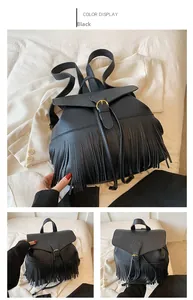 Détails d'un sac à dos en cuir noir avec pompon décoratif et boucle métallique