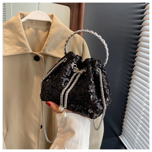 Detail of black sequined bucket bag with silver metal ring handle and pearl drawstring