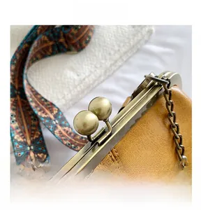 Detail of vintage mustard shell bag with bronze metal clasp and embroidered strap