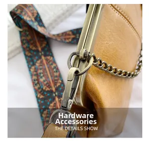 Detailed close-up of retro bronze clasp and colorful ethnic woven strap on leather bag