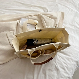 Canvas tote bag with multi-pocket interior and leather handles for daily organization