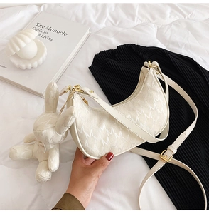 Détail du sac hobo blanc à motif M avec un pendentif lapin en peluche très mignon