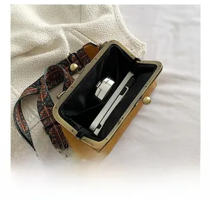 Detail of the yellow leather shell bag showing internal capacity and ethnic strap