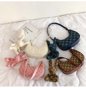 Détail de sacs en demi-lune en quatre couleurs avec breloques lapin et motifs en M