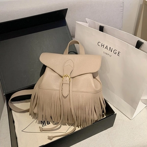 Sac à dos beige en cuir grainé avec glands, présenté dans son coffret cadeau de luxe