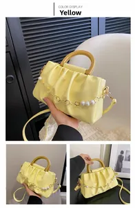 Détail du sac nuage jaune plissé avec chaîne décorative à fleurs dorées et perles