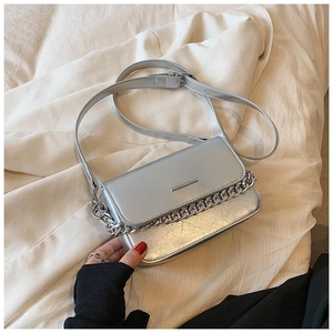 Detail of silver crossbody bag featuring cracked texture leather and metallic chain strap