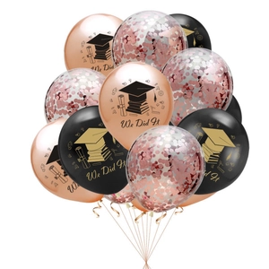 Detail of rose gold and black graduation balloons with We Did It text and glitter