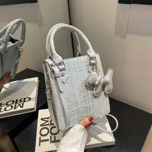 Blue and white tweed woven handbag with a cute puppy charm and a slim shoulder strap