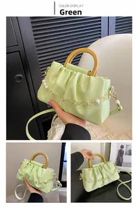 Détail du sac à main froncé vert menthe avec poignée en bois et chaîne de perles