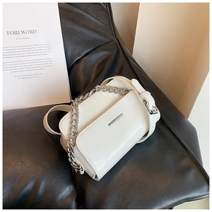 Detail of off-white crossbody bag with chunky silver chain and metal buckle on leather seat