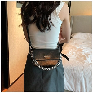 Back view of black oil wax leather crossbody bag with chain and gold metal buckle detail