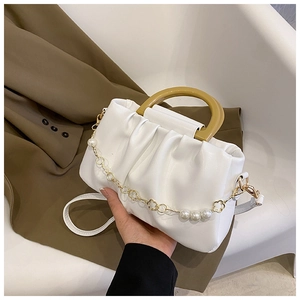 Détail du sac nuage blanc plissé avec poignée jaune et chaîne dorée à perles