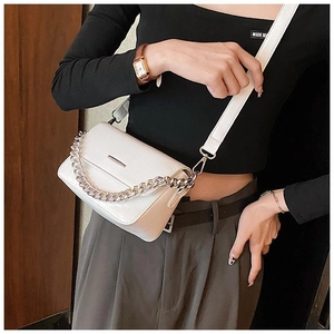 Detailed view of white crossbody bag with thick silver chain and premium leather texture