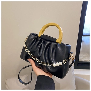Détail du sac nuage noir plissé avec poignée jaune et chaînes à fleurs perlées