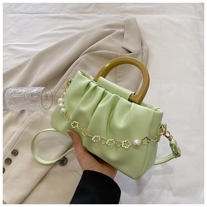 Détail du sac nuage plissé vert clair avec chaîne à fleurs en perles et poignée ambre