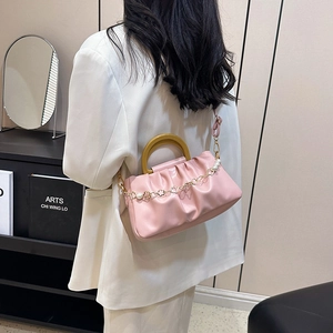 Sac nuage rose plissé avec poignée anneau jaune et détail chaîne dorée et perles