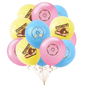 Close-up of pastel latex balloons with donut print and gold spiral ribbons for parties