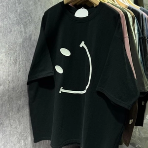 Détail de l'imprimé smiley blanc dessiné à la main sur un t-shirt en coton noir oversize