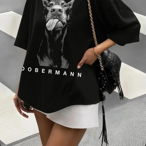 Détail d'un t-shirt ample en coton noir avec un imprimé graphique de Doberman