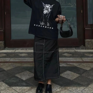 Détail d'un t-shirt en coton noir imprimé Dobermann et jupe utilitaire assortie à coutures blanches