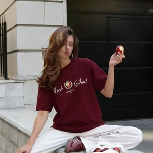 Détail d'un t-shirt Rich Soul bordeaux avec un pantalon blanc pour un style décontracté