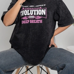 Détail d'un t-shirt en coton noir délavé avec imprimé graphique rose et style street