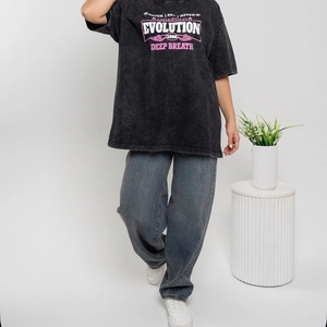 Vue complète d'un t-shirt noir délavé oversize avec graphismes rétro et jean large