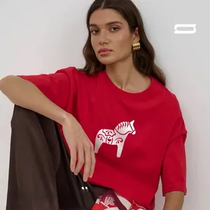 Detail of red cotton t-shirt with white graphic print showing fabric texture and loose fit