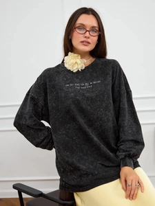Detail view of the mineral wash cotton texture and white vintage graphic print on the sweatshirt