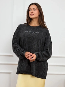 Detail of washed grey oversized cotton T-shirt featuring vintage slogan print texture