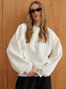Detail of white oversized sweatshirt with ribbed round neck and dropped shoulder seams