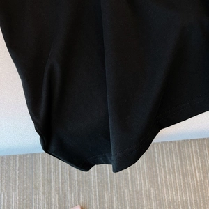 Détail de l'ourlet à double couture et du tissu en coton sergé sur un haut noir décontracté