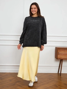 Washed black sweatshirt paired with pale yellow satin midi skirt for vintage look