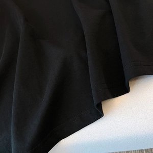 Détail du tissu en coton noir de haute qualité avec double couture robuste sur l'ourlet