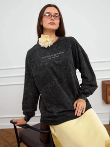 Detail of vintage washed gray cotton sweatshirt featuring white graphic text print