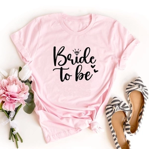Detail of pink cotton Bride to be t-shirt with artistic text, floral and shoe accents
